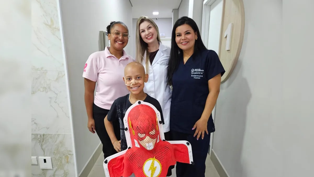 Menino com câncer recebe máscara do Flash para tratamento de radioterapia