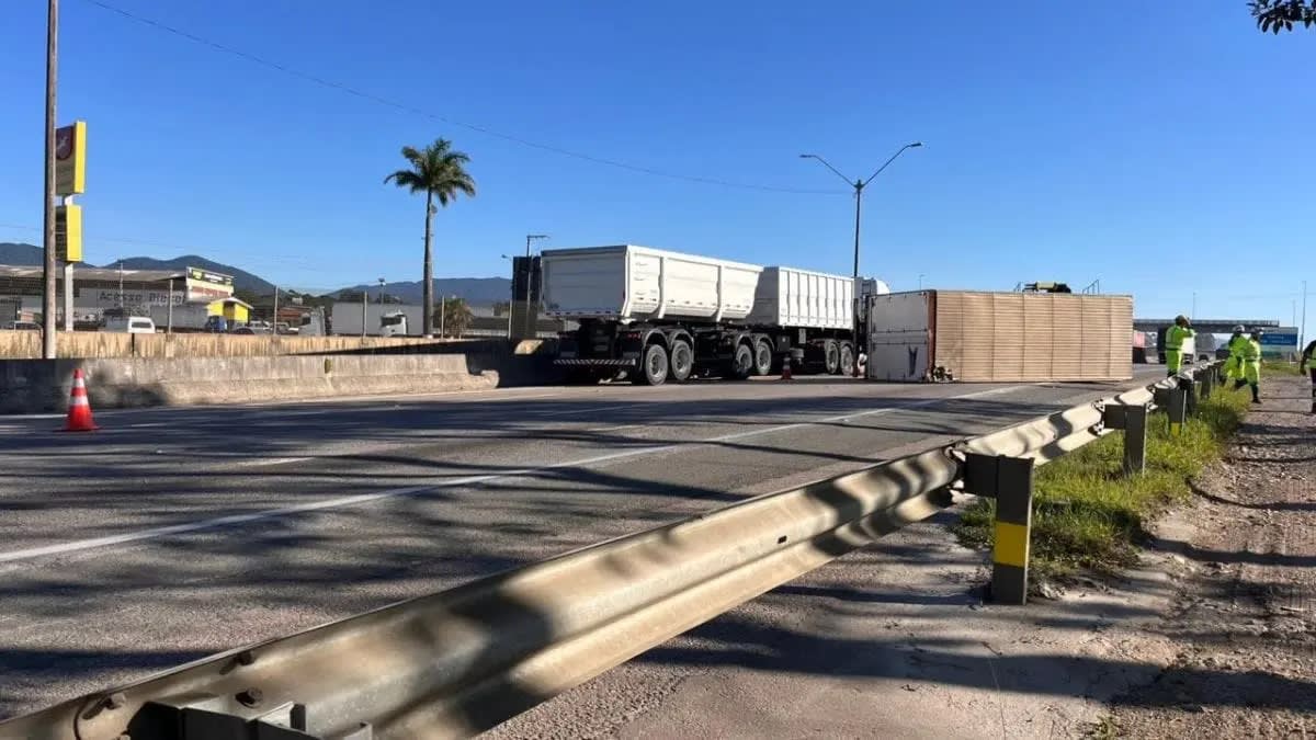 Caminhoneira tomba caminhão carregado de roupas na BR-101 em Porto Belo e escapa ilesa